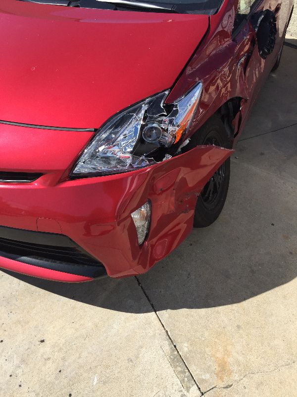Toyota Prius with damaged front bumper and headlight before repair